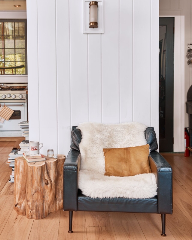 Rustic Modern Nook: Black Leather-like Chair & Log Stump Table.