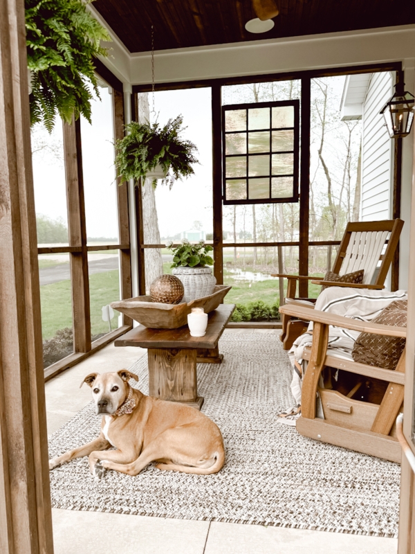 Rustic Porch with Pillar Leg Table, Textured Woven Rug & Hanging Ferns.