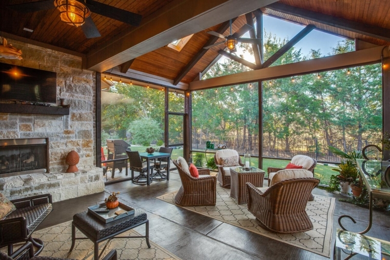 Rustic Stone Fireplace Porch with Vaulted Wood Ceiling & Woven Seating.