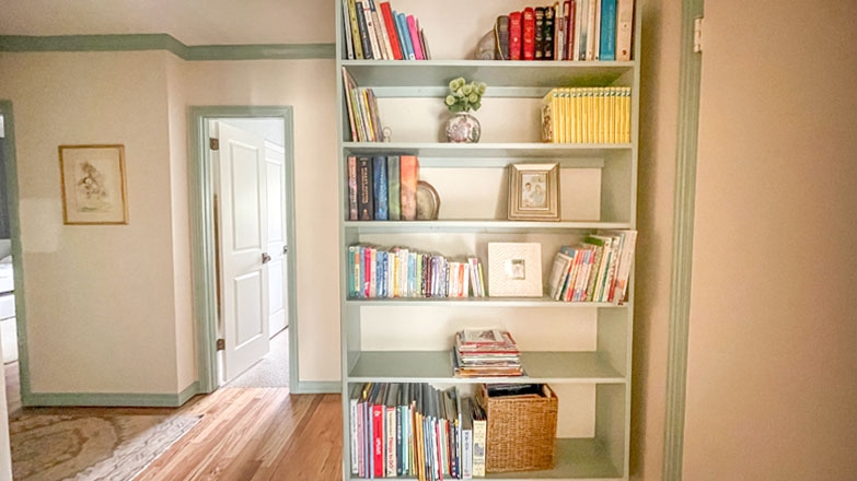 Sage Green Built-In Bookshelf in Hallway Nook with Crown Molding