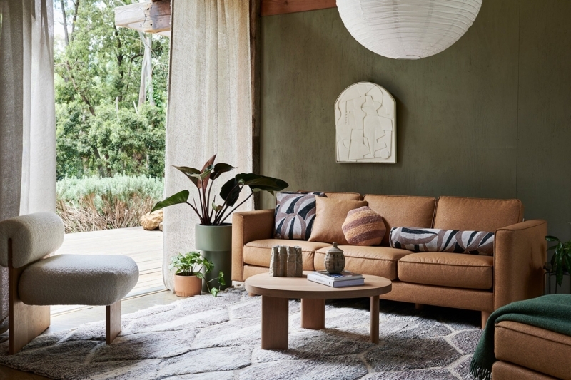 Sofa Tan Fabric against Olive Green Wall with Boucle Chair