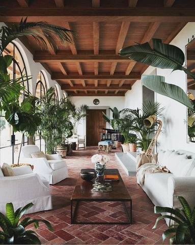 Spanish Revival Sunroom with Herringbone Tile Floor and Exposed Beams.