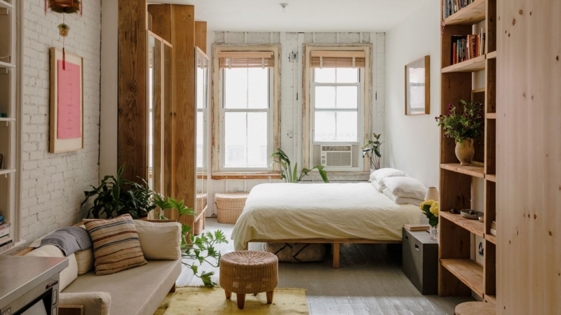 Studio Layout with White Brick Wall, Wood Shelving and Boho Bed Design