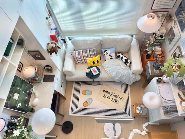 Studio Living Area with Graphic Text Rug and Minimalist White Decor