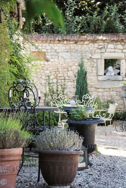 Terrace Decor With A Rubble Stone Backdrop & Ornate Ironwork