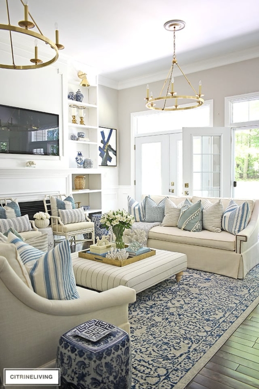 Traditional Coastal Living Room Brass Chandeliers & Striped Ottoman