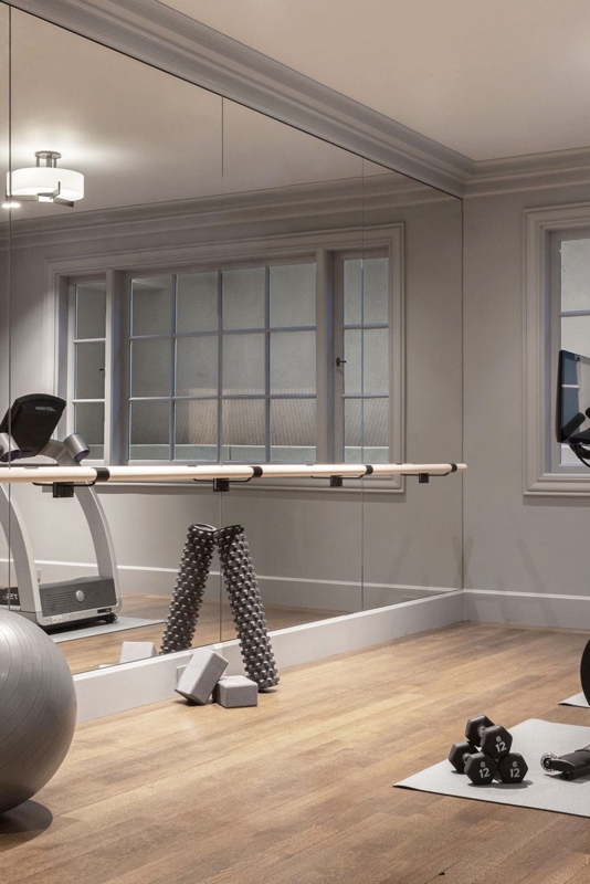 Transitional Home Gym Setup With Mirrored Wall And Ballet Barre