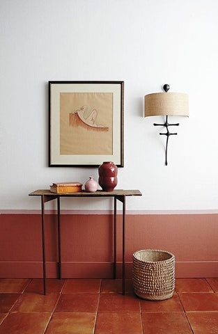 Two-Tone Wall Entryway with Sculptural Sconce and Clay Floor Tiles.