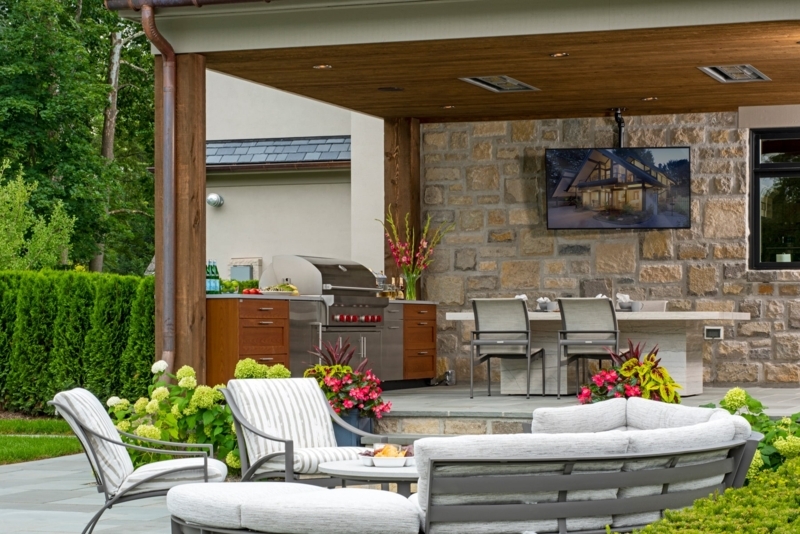 Upscale Outdoor Living Room with Curved Sectional and Stone Veneer