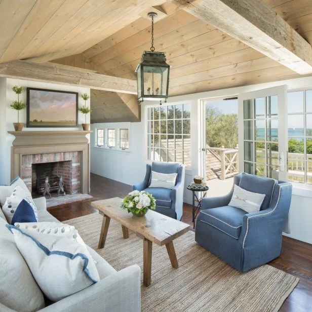 Vaulted Plank Ceiling and Rustic Beams in Coastal Living Room with Blue Chairs