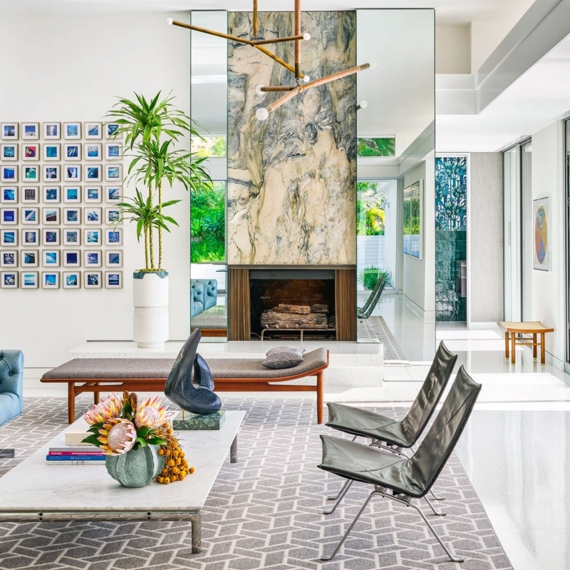 Veined Stone Fireplace with Mirrored Flanking Panels in Modern Room