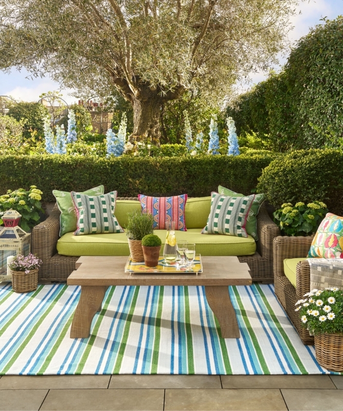 Vibrant Wicker Outdoor Sofa: Lime Green Upholstery & Striped Rug