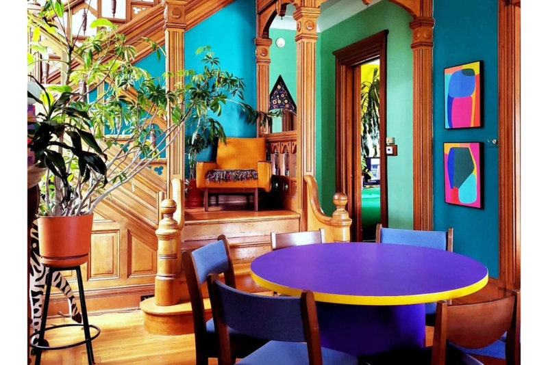 Victorian Dining Room with Ornate Wood Columns and Purple Table