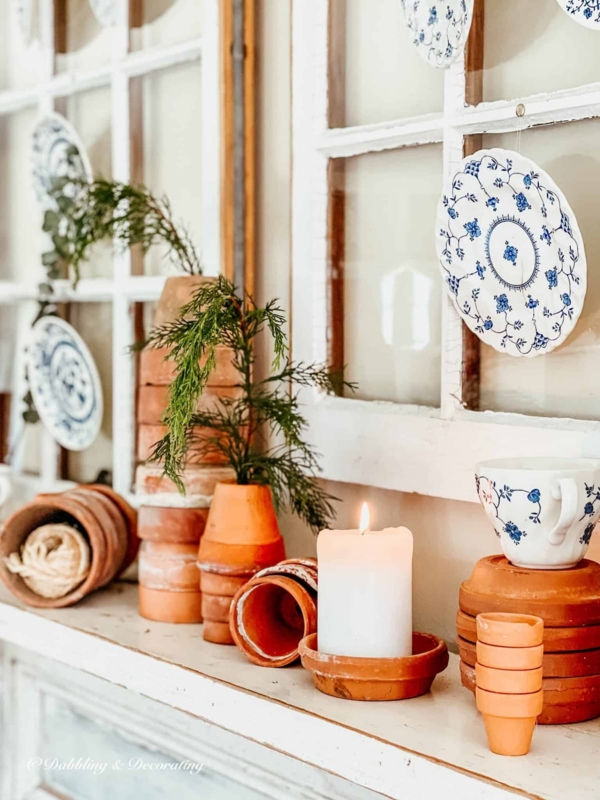 Vignette: Stacked Terracotta Pots, Vintage Plates, Salvaged Window Backdrop