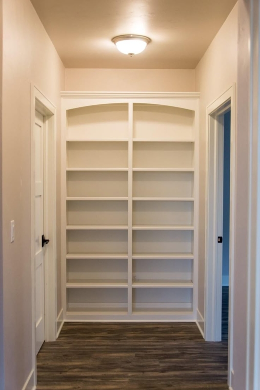 White Built-In Bookcase with Arched Top Header in Hallway