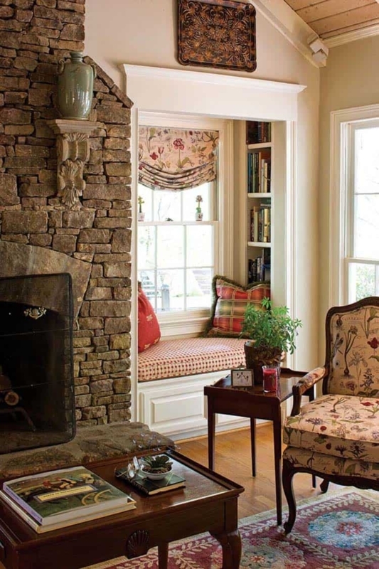 Window Seat Reading Nook with Stacked Stone Fireplace & Floral Accents.