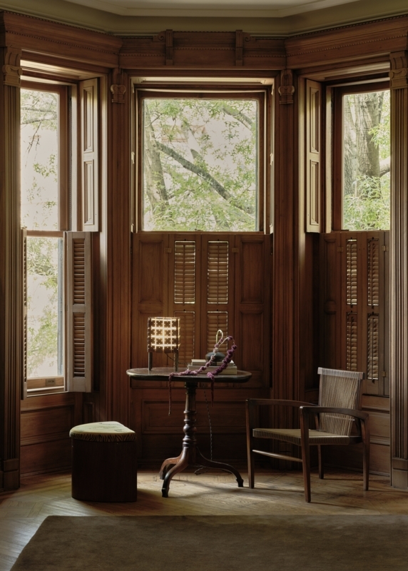 Wood-Paneled Bay Window Nook with Woven Armchair and Herringbone Floor