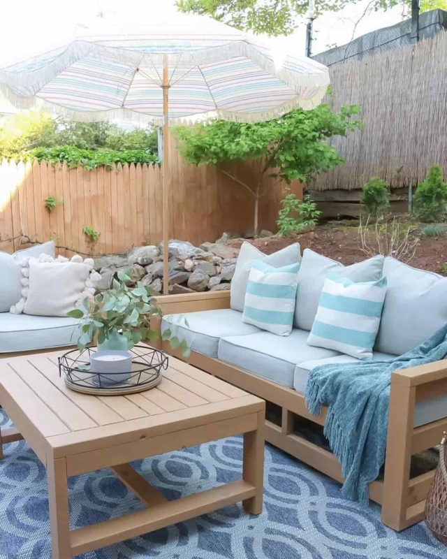 Wood-Toned Outdoor Sectional Sofa with Fringed Patio Umbrella