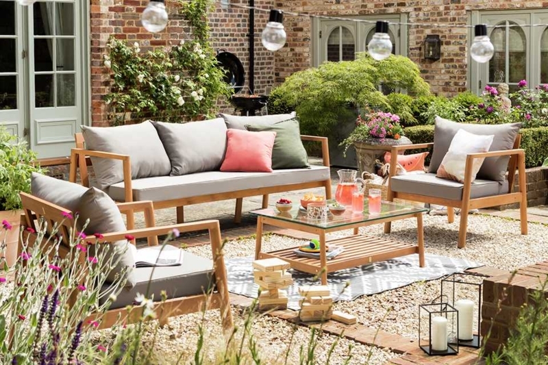 Wood-Toned Patio Furniture Set with Coral Accents in Gravel Setting